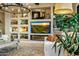 Living room with built-in shelving, fireplace, and large screen TV at 40903 N Harbour Town Way, Anthem, AZ 85086