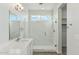 Bright bathroom featuring marble tile shower with glass door, white vanity, and modern fixtures at 31824 N 221St Dr, Wittmann, AZ 85361