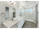 Bathroom with a dual sink vanity, undermount sinks, quartz countertop, framed mirrors and a walk-in shower at 31824 N 221St Dr, Wittmann, AZ 85361