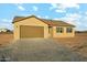 A single-story tan home with a brown roof, brown shutters, and a two-car garage under a cloudy blue sky at 31824 N 221St Dr, Wittmann, AZ 85361