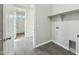 Laundry room featuring gray wood-look floors, neutral paint, and white trim at 31824 N 221St Dr, Wittmann, AZ 85361