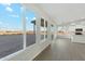 A brightly-lit living room features grey wood-look floors and has access to the kitchen and the backyard at 31824 N 221St Dr, Wittmann, AZ 85361