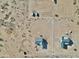 Aerial view of a construction site, showing lot and neighboring homes with a desert landscape and heavy equipment at 25721 W Running Deer Trl, Wittmann, AZ 85361