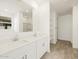 Double vanity bathroom with white cabinets and a large mirror at 22514 W Tonopah Dr, Surprise, AZ 85387