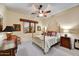 Cozy bedroom with gold bed frame, a ceiling fan, and a window with wood trim at 2744 S First Water Ln, Gold Canyon, AZ 85118