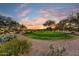 Picturesque view of the golf course, desert vegetation, and a colorful sunset sky at 2744 S First Water Ln, Gold Canyon, AZ 85118