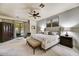 Comfortable main bedroom features neutral tones, carpeted floors, ceiling fan, and a sitting area with a view of the property's exterior at 2744 S First Water Ln, Gold Canyon, AZ 85118