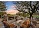 Cozy outdoor fireplace with comfortable seating area and desert landscaping at sunset at 2744 S First Water Ln, Gold Canyon, AZ 85118