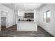 Open concept kitchen with granite counters, stainless appliances, and wood-look flooring at 24579 W St Catherine Ave, Buckeye, AZ 85326