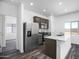 Modern kitchen with stainless steel appliances, granite countertops, and wood-look flooring at 24579 W St Catherine Ave, Buckeye, AZ 85326