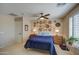 Well-lit bedroom featuring a ceiling fan, window shutters, and stylish wall decor at 29205 N Yellow Bee Dr, San Tan Valley, AZ 85143