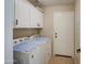 Bright laundry room with washer, dryer, and overhead cabinets at 29205 N Yellow Bee Dr, San Tan Valley, AZ 85143