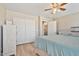 Bright bedroom with light wood floors, ceiling fan, and white closet with sliding doors at 1448 E Poncho Ln, San Tan Valley, AZ 85143