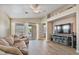 Cozy living room features neutral colors, wood floors, recessed lighting, and sliding glass door to backyard at 1448 E Poncho Ln, San Tan Valley, AZ 85143