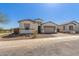 An exterior view of a single story home with a two car garage and gravel front yard at 11937 W Parkway Ln, Avondale, AZ 85323
