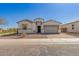 An exterior view of a single story home with a two car garage and gravel front yard at 11937 W Parkway Ln, Avondale, AZ 85323
