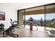 Home gym with exercise equipment and expansive windows offering panoramic views of the city and desert landscape at 4301 E Upper Ridge Way, Paradise Valley, AZ 85253