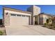 View of the two car garage, with stone facade and concrete driveway at 21864 E Sunset Dr, Queen Creek, AZ 85142