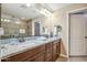 Bathroom with double sinks, a granite countertop, stylish mirrors, and a glass-enclosed shower at 2425 W Bronco Butte Trl # 1002, Phoenix, AZ 85085