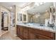 Bathroom with double sinks, granite countertop, large mirror, and an accessible walk-in shower at 2425 W Bronco Butte Trl # 1002, Phoenix, AZ 85085