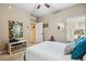 A neutral bedroom featuring a ceiling fan, natural light, and a decorative mirror at 2425 W Bronco Butte Trl # 1002, Phoenix, AZ 85085