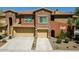 Multi-unit townhouse exterior with stone accents, well-kept landscaping, and convenient garage access at 2425 W Bronco Butte Trl # 1002, Phoenix, AZ 85085