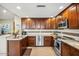 A kitchen featuring rich wood cabinets, stainless steel appliances, and a stylish backsplash at 2425 W Bronco Butte Trl # 1002, Phoenix, AZ 85085