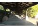 Covered walkway with stone pillars and lush greenery, leading to a serene outdoor bench at 2425 W Bronco Butte Trl # 1002, Phoenix, AZ 85085