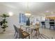 Spacious dining area with glass top table, view into kitchen, and plantation shutters at 15418 W Big Sky Dr, Surprise, AZ 85374