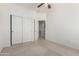 Bedroom boasts carpet flooring, a ceiling fan, and closet with sliding doors to maximize space at 1451 E Palm Beach Dr, Chandler, AZ 85249
