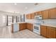 Bright kitchen features wood cabinets, white appliances, tile flooring, and sliding doors to the outdoor patio at 1451 E Palm Beach Dr, Chandler, AZ 85249