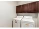 Laundry room with washer, dryer, and wooden cabinets at 18009 W Ivy Ln, Surprise, AZ 85388