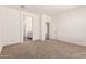 A carpeted bedroom showcasing an open doorway into an en-suite bathroom at 18162 W Cielo Grande Ave, Surprise, AZ 85387