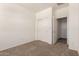 Bedroom with carpet flooring featuring a closet with sliding doors and an open doorway at 18162 W Cielo Grande Ave, Surprise, AZ 85387