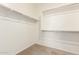 An empty walk-in closet featuring carpeted flooring and built-in shelving for optimal storage at 18162 W Cielo Grande Ave, Surprise, AZ 85387
