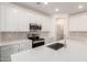 Modern kitchen boasts white cabinets, stainless steel appliances, and quartz countertops at 18162 W Cielo Grande Ave, Surprise, AZ 85387