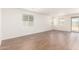 Bright living room with wood-look tile flooring and large windows at 18162 W Cielo Grande Ave, Surprise, AZ 85387