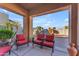 Relaxing patio with red striped chairs and fire pit, overlooking a desert landscape at 2012 E Valencia Dr, Phoenix, AZ 85042