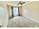 Bedroom featuring a ceiling fan and a window with nice curtains and neutral carpet at 23200 W Ashleigh Marie Dr, Buckeye, AZ 85326