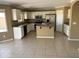 Eat-in kitchen features white cabinets, stainless steel appliances, an island, and tile floors at 29101 N Yellow Bee Dr, San Tan Valley, AZ 85143