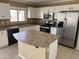 Modern kitchen boasts white cabinets, stainless steel appliances, and a functional center island at 29101 N Yellow Bee Dr, San Tan Valley, AZ 85143