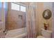 Well-lit bathroom featuring a bathtub with decorative shower curtain and tiled walls at 37269 N 100Th Pl, Scottsdale, AZ 85262