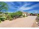 Brick driveway and desert landscape views highlight this home's three-car garage and charming exterior at 37269 N 100Th Pl, Scottsdale, AZ 85262