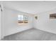Clean bedroom showcasing neutral carpet, white walls, and several windows offering natural light at 10864 E Texas Ave, Mesa, AZ 85212