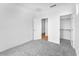 Clean bedroom view showcasing neutral carpet, white walls, closet and door leading to another room at 10864 E Texas Ave, Mesa, AZ 85212