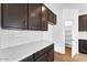 Kitchen featuring modern appliances, white countertops, and dark wood cabinets at 10864 E Texas Ave, Mesa, AZ 85212