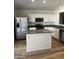 Bright kitchen features stainless steel appliances, white cabinetry, an island and wood-look flooring at 5036 E Roy Rogers Rd, Cave Creek, AZ 85331