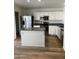 Bright kitchen features stainless steel appliances, white cabinetry, an island and wood-look flooring at 5036 E Roy Rogers Rd, Cave Creek, AZ 85331