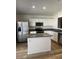 Bright kitchen features stainless steel appliances, white cabinetry, an island and wood-look flooring at 5036 E Roy Rogers Rd, Cave Creek, AZ 85331