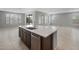A spacious kitchen island with a stainless steel sink and a dark wood cabinet base is centrally located in a large living area at 7691 W Cactus Wren Way, Florence, AZ 85132